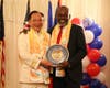 Dr. Hong, left, presents the Compass Clock of Conscience to Hans Garry Dorlean, founder and honorary president of Society in Action.
