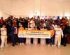 Attendees make an energy hand gesture while posing for a group photo with a banner promoting the Declaration of Transparency and Integrity during the 222nd anniversary of the Haitian Flag in Brooklyn, New York on May 18, 2025.