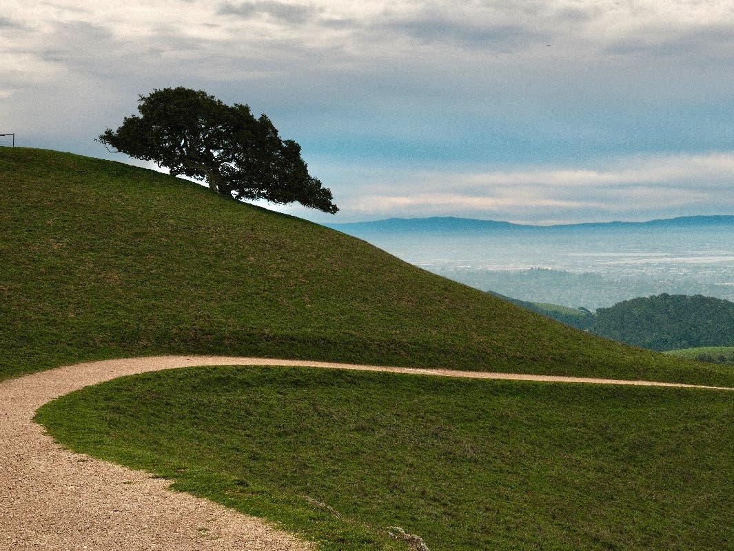 The photo captures a breathtaking view of clouds slightly covering the hills below. 