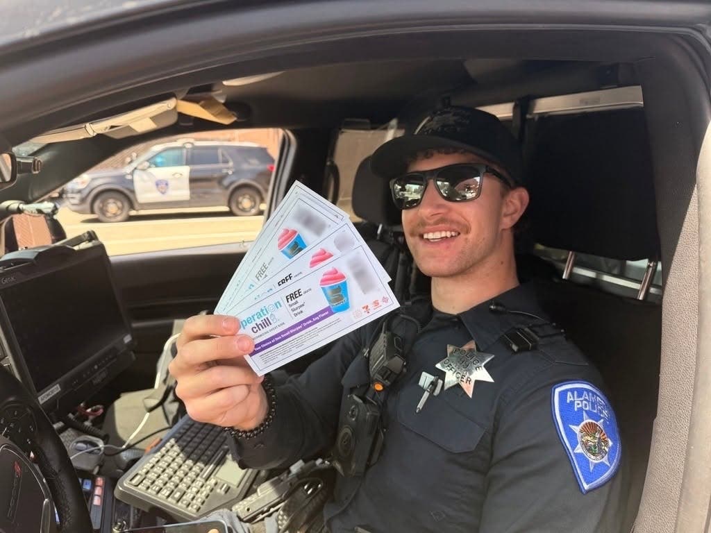 A photo of an Alameda officer with Slurpee coupons.