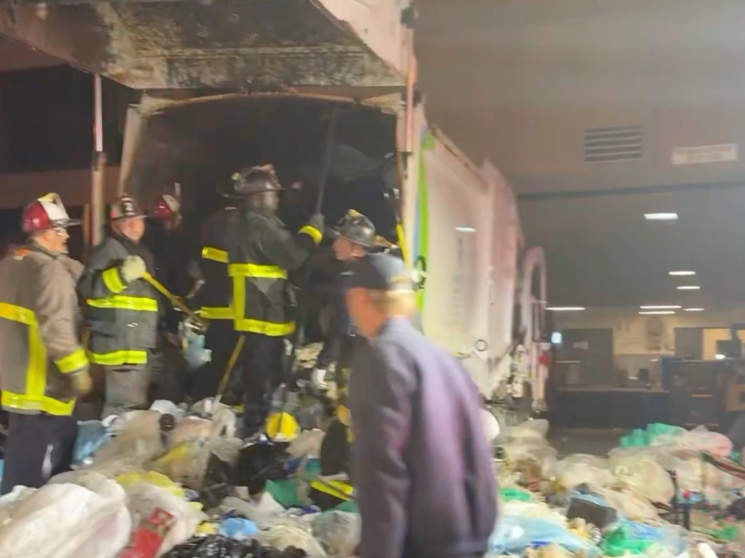 Fire crews work to remove a person trapped inside a garbage truck in San Francisco. 