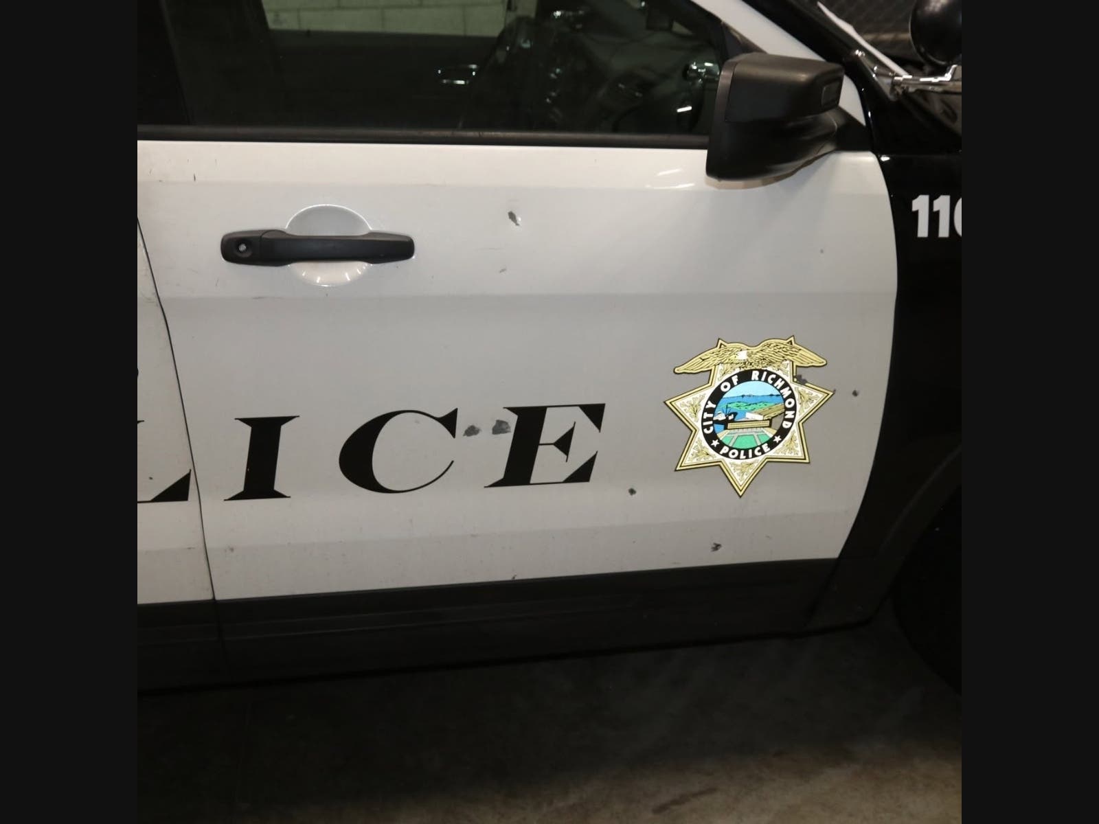 A photo of a bullet-hole-ridden squad car. 