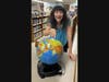 Library staff pointing to a globe from the Library of Things in Dartmouth. 