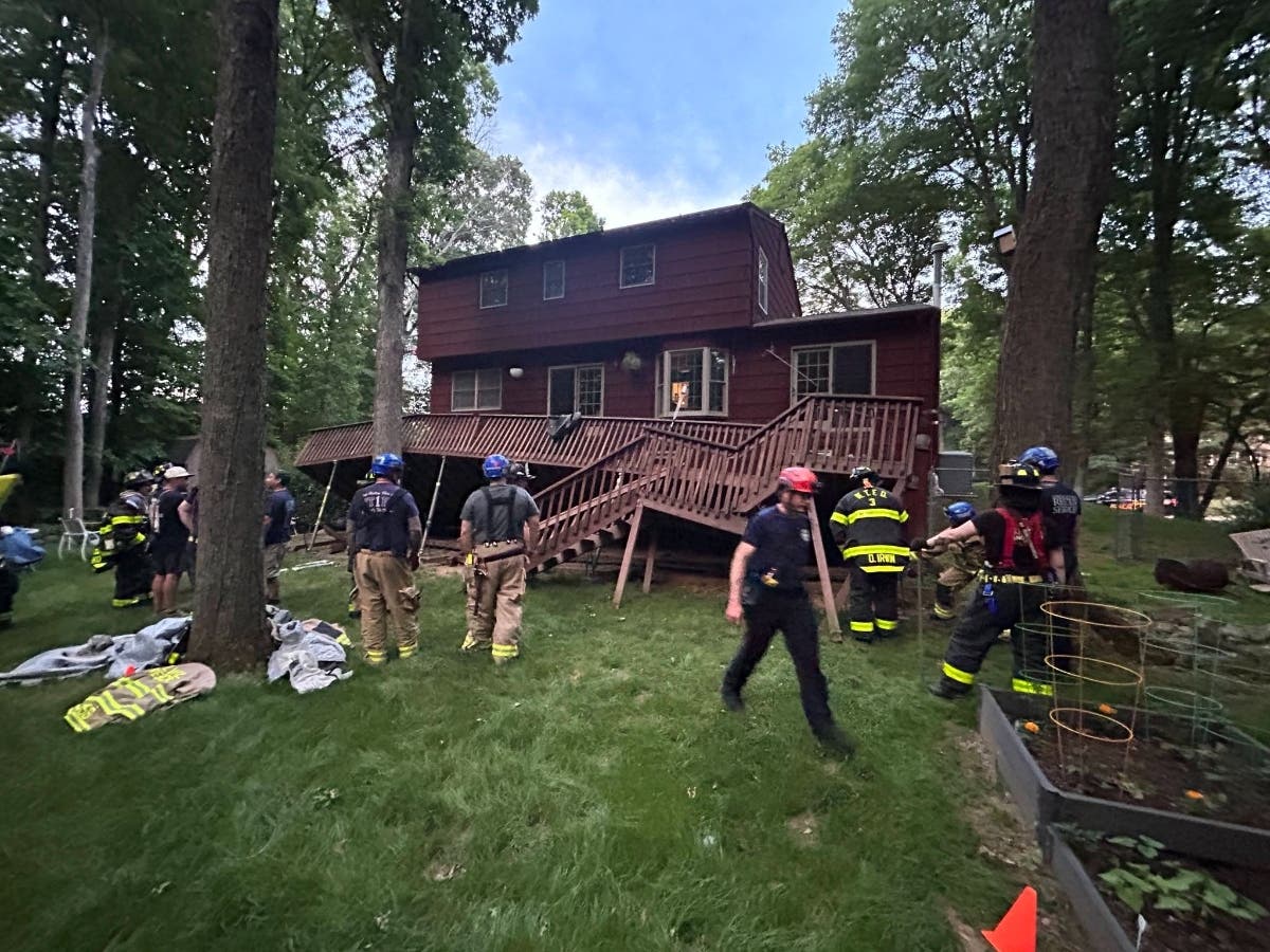 Authorities discovered that a back deck several feet off the ground had detached from the home and fallen. Officials said it was hung up on a tree "with further danger of collapse."