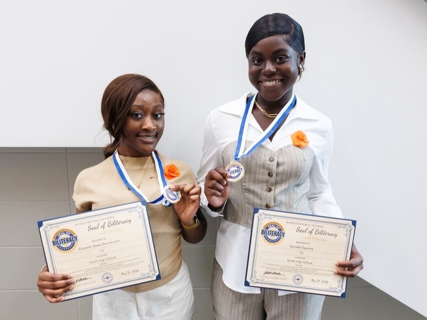 Elizabeth Abeka-Bannerman (left) and Danielle Oppong (right) of North High School hold their Massachusetts State Seal of Biliteracy with Distinction certificate and medal following Worcester Public Schools’ annual Seal of Biliteracy Ceremony on