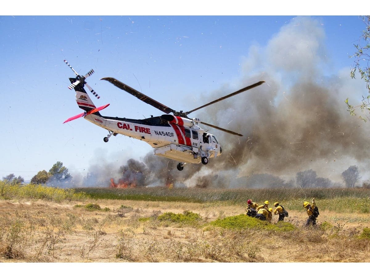 A vehicle fire sparked a difficult-to-reach marsh blaze that forced temporary evacuations before crews brought it under control.