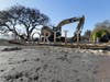 A backhoe stands ready in the background after a groundbreaking ceremony at the fire damaged Signorello Estate winery in 2018. The groundbreaking took place one year and one day after the winery burned to the ground in the October 2017 Atlas Fire.