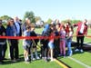 Dr. Sanchez, joined by students and community members, cuts the ceremonial ribbon to officially unveil the new athletic field at Washington Irving School.