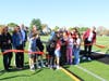 Dr. Sanchez, joined by students and community members, cuts the ceremonial ribbon to officially unveil the new athletic field at Washington Irving School.