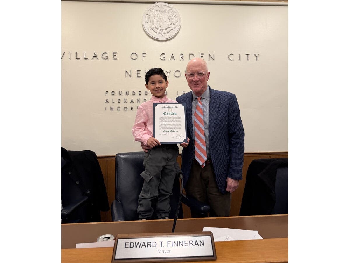 Mayor Ed Finneran presents a Village citation to Stratford School third-grader Owen Galarza, recognizing his first-place speech in an oratorical contest in Washington, D.C.