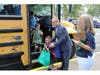 Dr. Famularo helped students equip their backpacks after stepping off the bus.