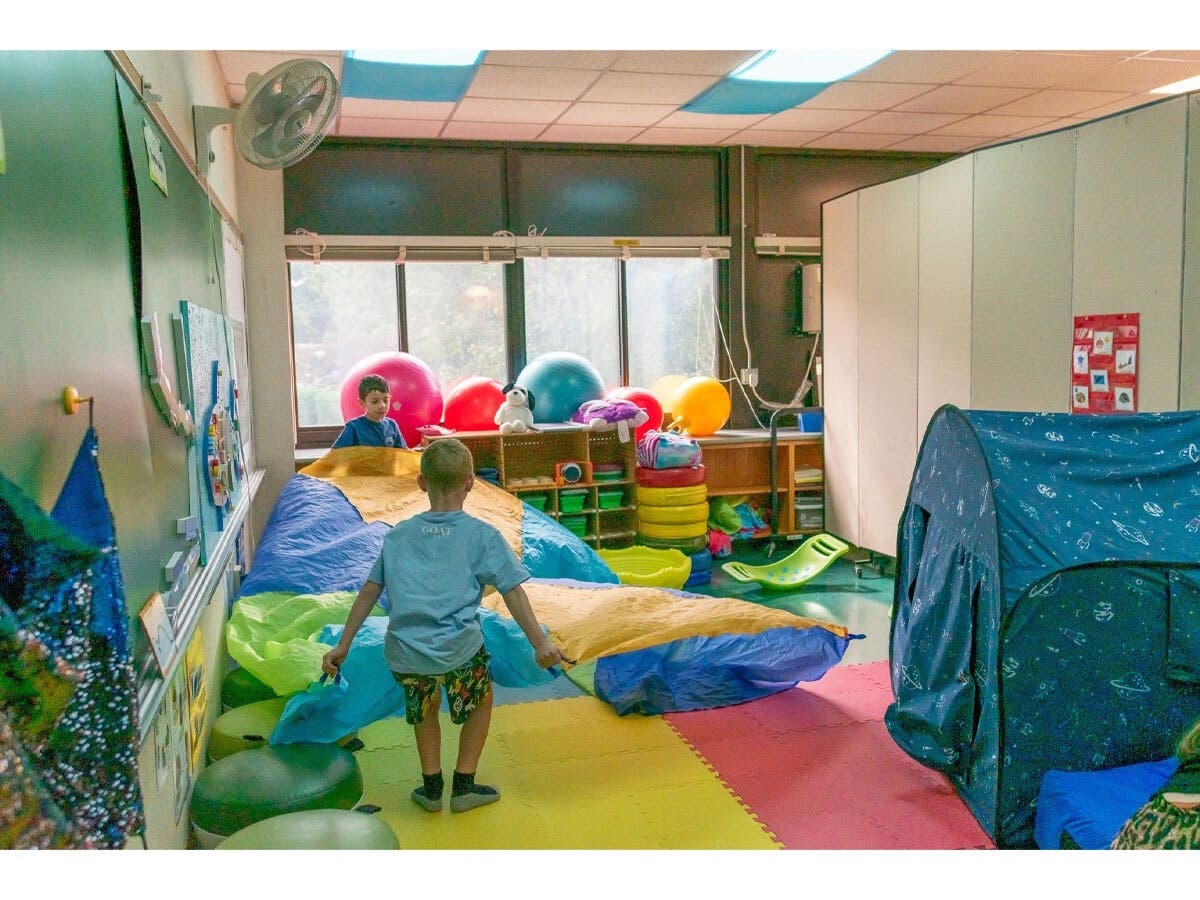 Two Northside Elementary students lift a play parachute during a movement break in
the school’s sensory room.