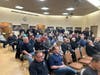 Members of the Smithtown Fire Department and invited Central Islip Fire Department members listen during a department meeting that paused for a surprise reunion and heartfelt thank-you more than 50 years in the making.