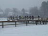 First responders and bystanders gather along a dock at Gibbs Pond following the rescue of a child and an adult who fell through the ice Saturday afternoon.