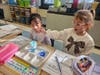 Kindergarten students at William E. DeLuca Elementary School observe as water drips through a cotton “cloud” during a weather science experiment focused on cloud formation and rainfall.