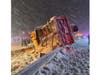 Emergency responders work at the scene of an overturned snowplow on westbound Sunrise Highway as snow falls Sunday night.