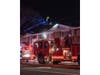 A ladder truck is extended above a multi-occupancy building as firefighters work to extinguish a blaze on Great East Neck Road in West Babylon. The fire was brought under control in about an hour, officials said.