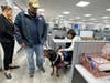 Service dog Nova interacts with visitors during a visit to Miller & Caggiano, LLP alongside veteran Mike Kilano and local officials.
