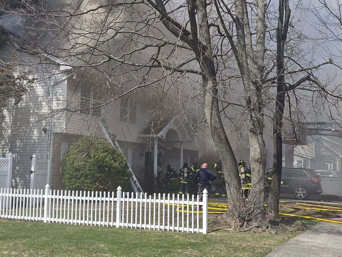 Heavy smoke billows from a house fire on South Broadway in Lindenhurst as firefighters respond to the scene.
