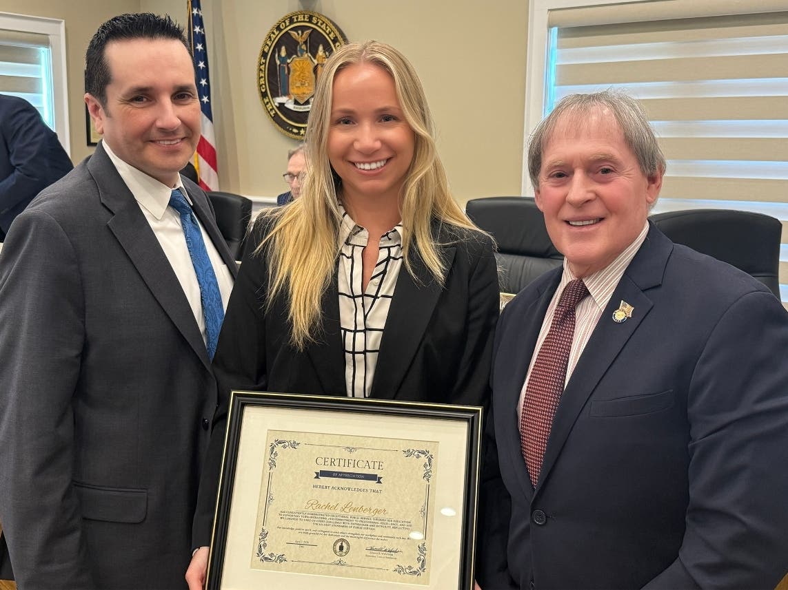 Assistant Town Attorney Rachel Lenberger, center, was recognized as the Town of Smithtown’s Employee of the Month for April 2026 during a recent Town Board meeting, joined by Town Supervisor Edward R. Wehrheim and members of the Town Board.