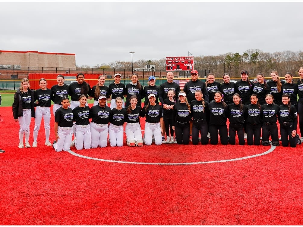The East Islip varsity softball team celebrates a 14–2 win over Bellport during the inaugural Laney McGowan Legacy Game on March 18.