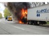 Flames engulf the front of a tractor-trailer on Veterans Highway as emergency responders arrive on scene. Thick black smoke could be seen rising from the vehicle.