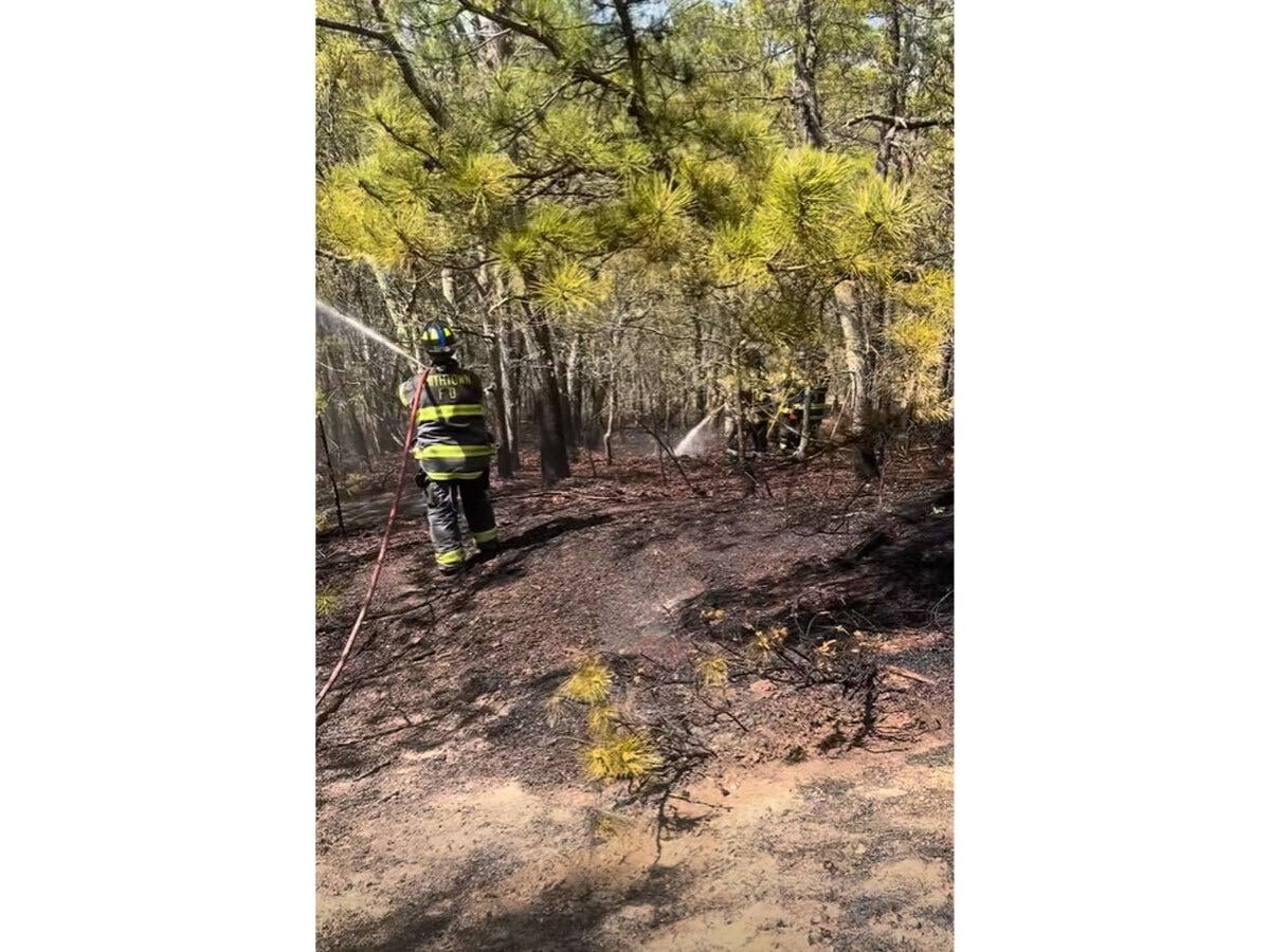 Firefighters respond to a brush fire behind Morewood Park in Smithtown that burned approximately a 200-by-150-foot area Sunday afternoon.