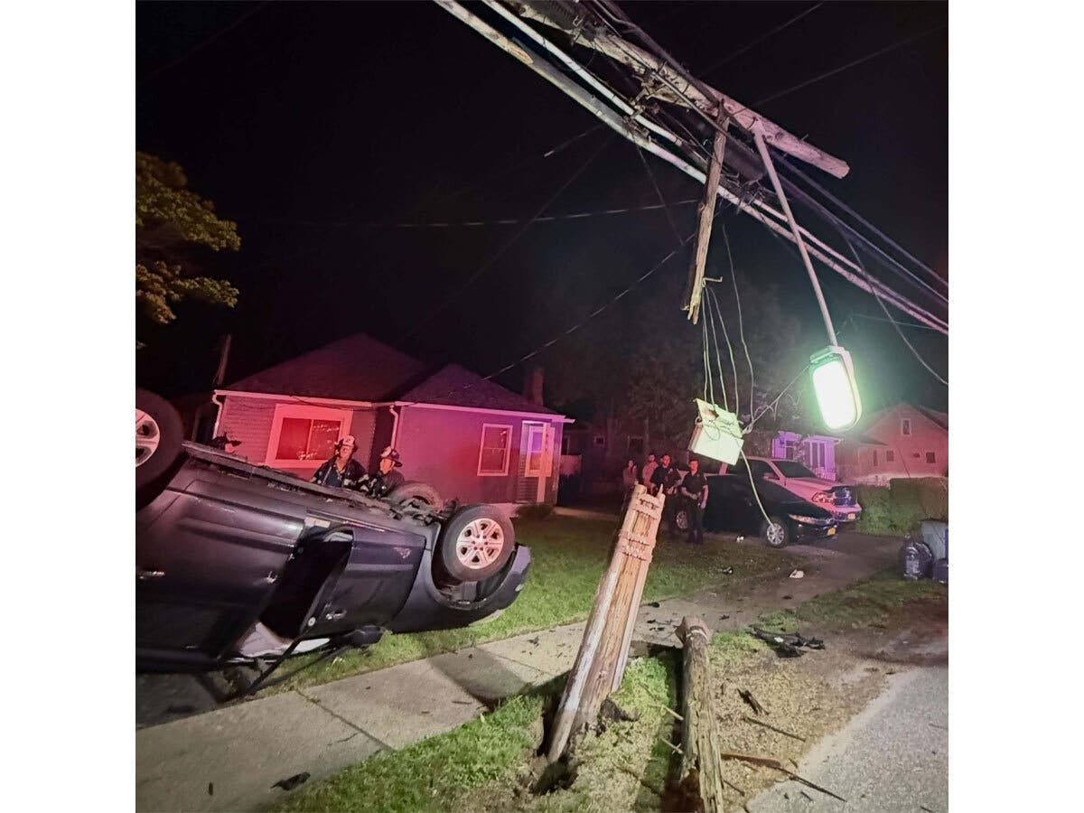 An overturned vehicle rests on a sidewalk after crashing into a utility pole on Moffitt Boulevard in Islip early Wednesday morning.