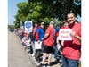 Union members hold signs calling for “fair wages” during a strike demonstration outside Babylon station.