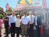 Town officials and community partners gathered near a sausage-and-braciole vendor during the Town of Babylon Italian Food Festival.