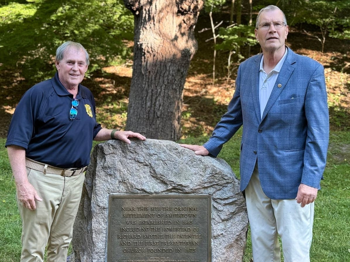 A North Shore village with roots dating back to Smithtown’s earliest colonial settlement marked a major milestone Friday with the unveiling of a new stone monument.