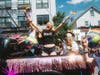 Participants wave Pride flags from a decorated vehicle during the Babylon Pride Parade.  