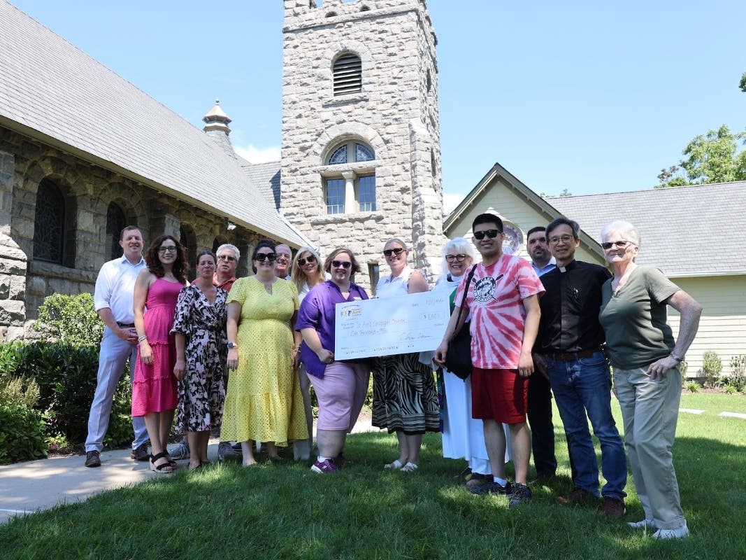 Representatives from People’s Arc of Suffolk and St. Ann’s Episcopal Church pose with a $1,000 donation toward restoration of the historic Sayville church’s bell tower.