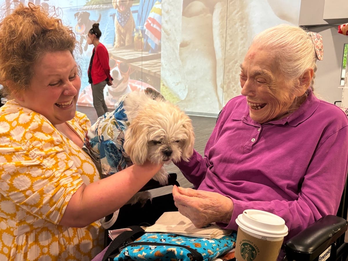 Therapeutic Recreation Leader Lauren Bacotti, with her dog, Duke, and Gurwin resident Marjorie Schoneboom.