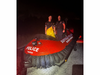 Suffolk County Police Marine Bureau officers stand with Marine Hovercraft Tango after rescuing a family whose boat ran aground in the Fire Island Inlet.