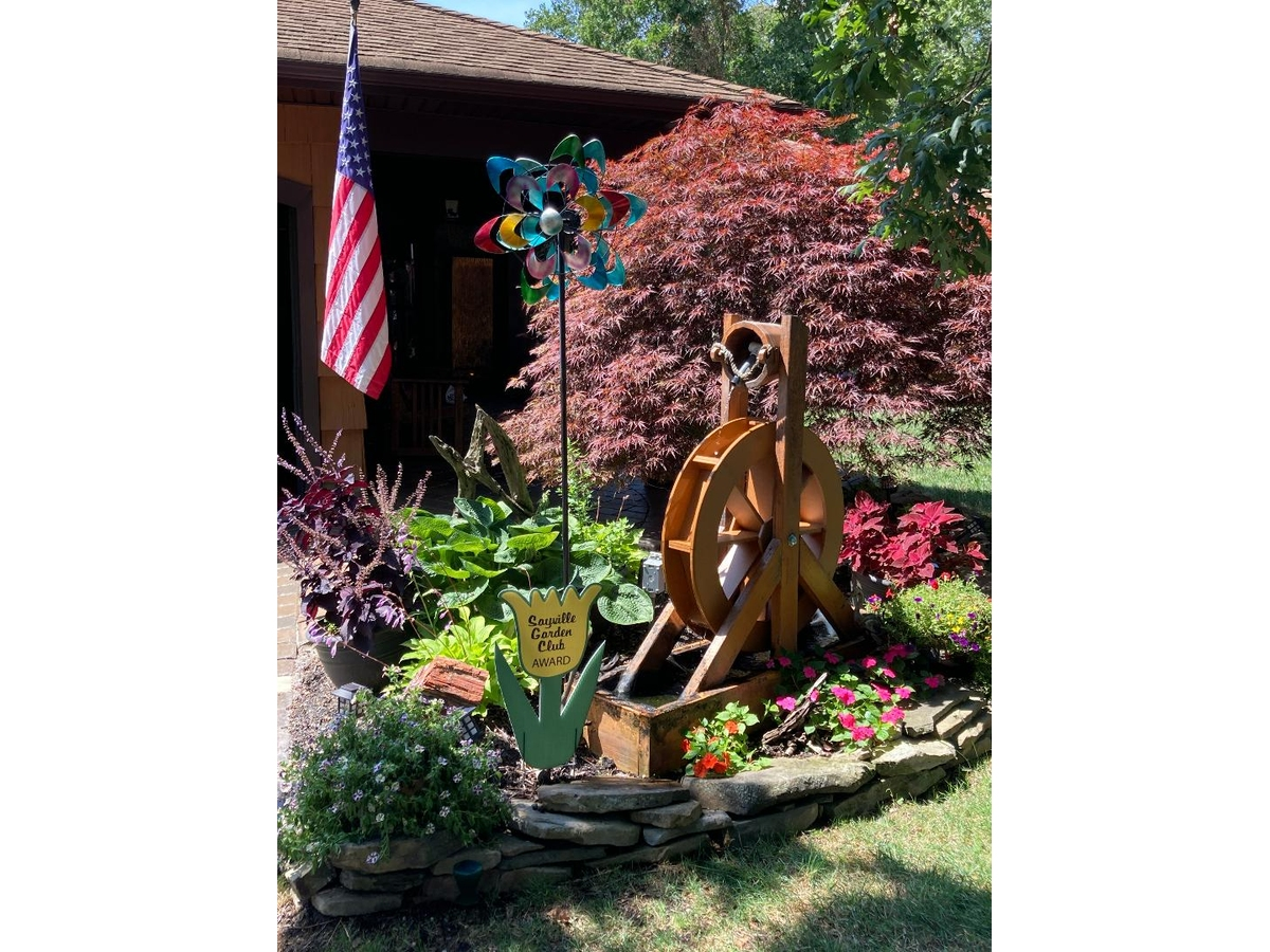 Stu Parker’s Astor Drive yard in Sayville, highlighted by a working water wheel, received a 2026 Sayville Garden Club Beautification Award.