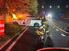 A Sayville firefighter approaches a burning vehicle on the eastbound Sunrise Highway service road at Lincoln Avenue early Wednesday morning.