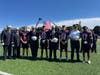 The Bay Shore Varsity Football team presents commemorative game balls to representatives from the Bay Shore Fire Department, the Bay Shore-Brightwaters Rescue Ambulance, and the Suffolk County Police Department.
