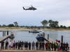 Emergency responders gather at the Kings Park Bluff as an Army National Guard helicopter flies overhead during a marine rescue training exercise.