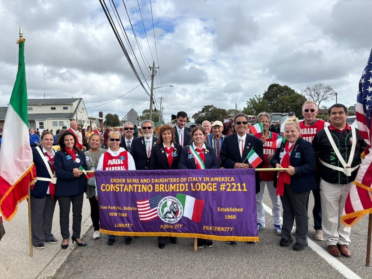 Members of the Constantino Brumidi Lodge #2211 and fellow participants gather behind the lodge's banner during a Long Island Columbus Day Parade in Deer Park.