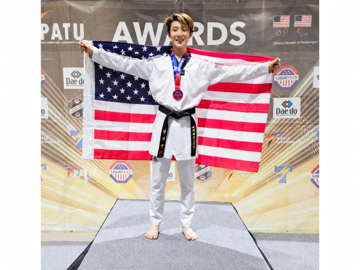 Walt Whitman High School senior Preston Park displays his medal and the American flag at a taekwondo awards ceremony. Park earned his fourth USA Taekwondo national-team selection in 2026.