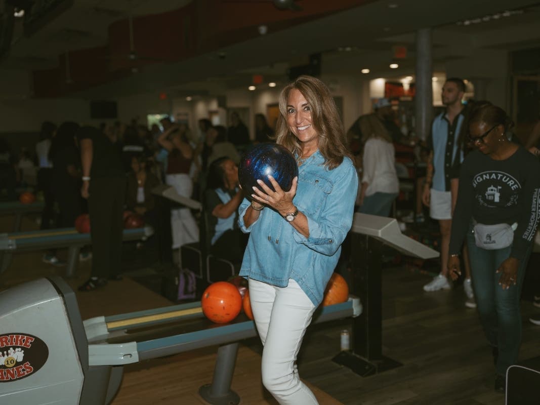 A Signature Premier Properties team member prepares to bowl during a fundraiser at Strike 10 Lanes in Deer Park.
