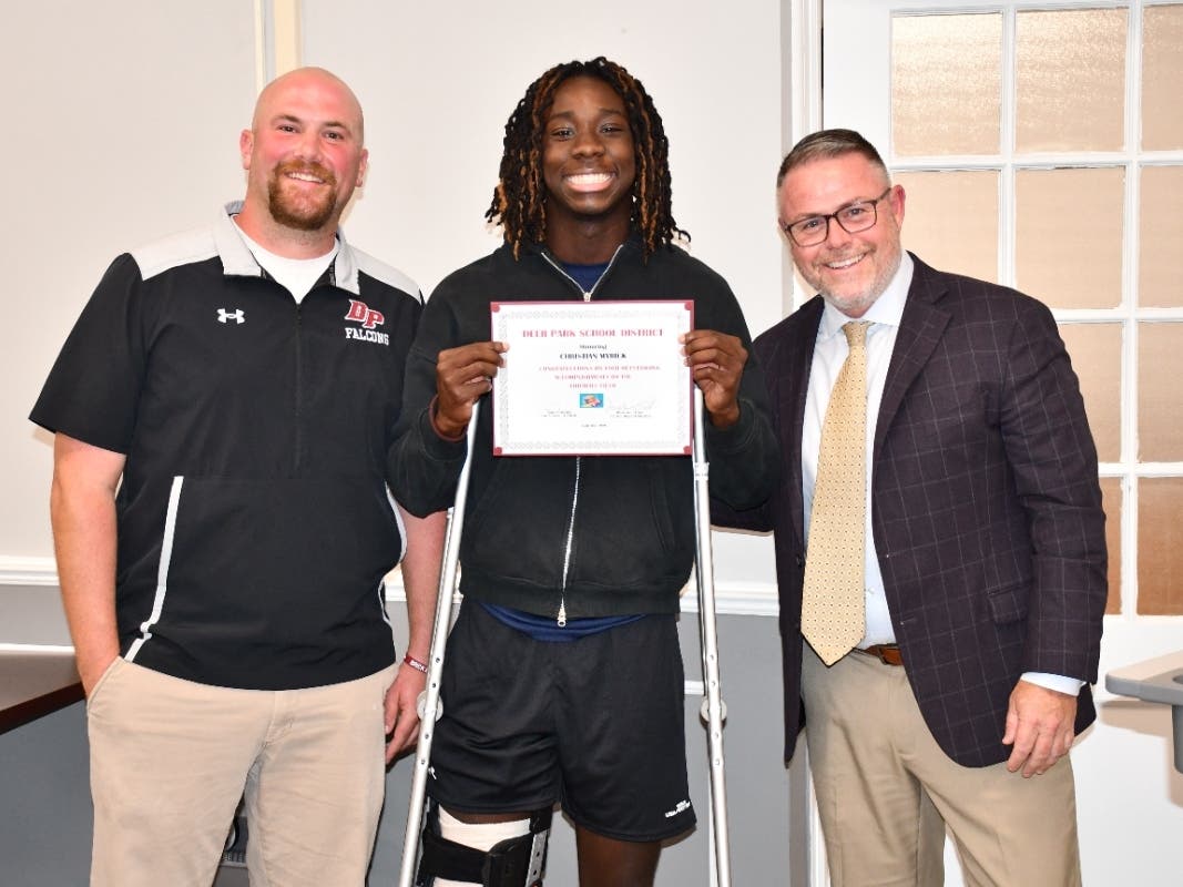 Deer Park High School ninth grader Christian Myrick, center, was recognized by the Board of Education for his standout freshman football season and All-State honors.
