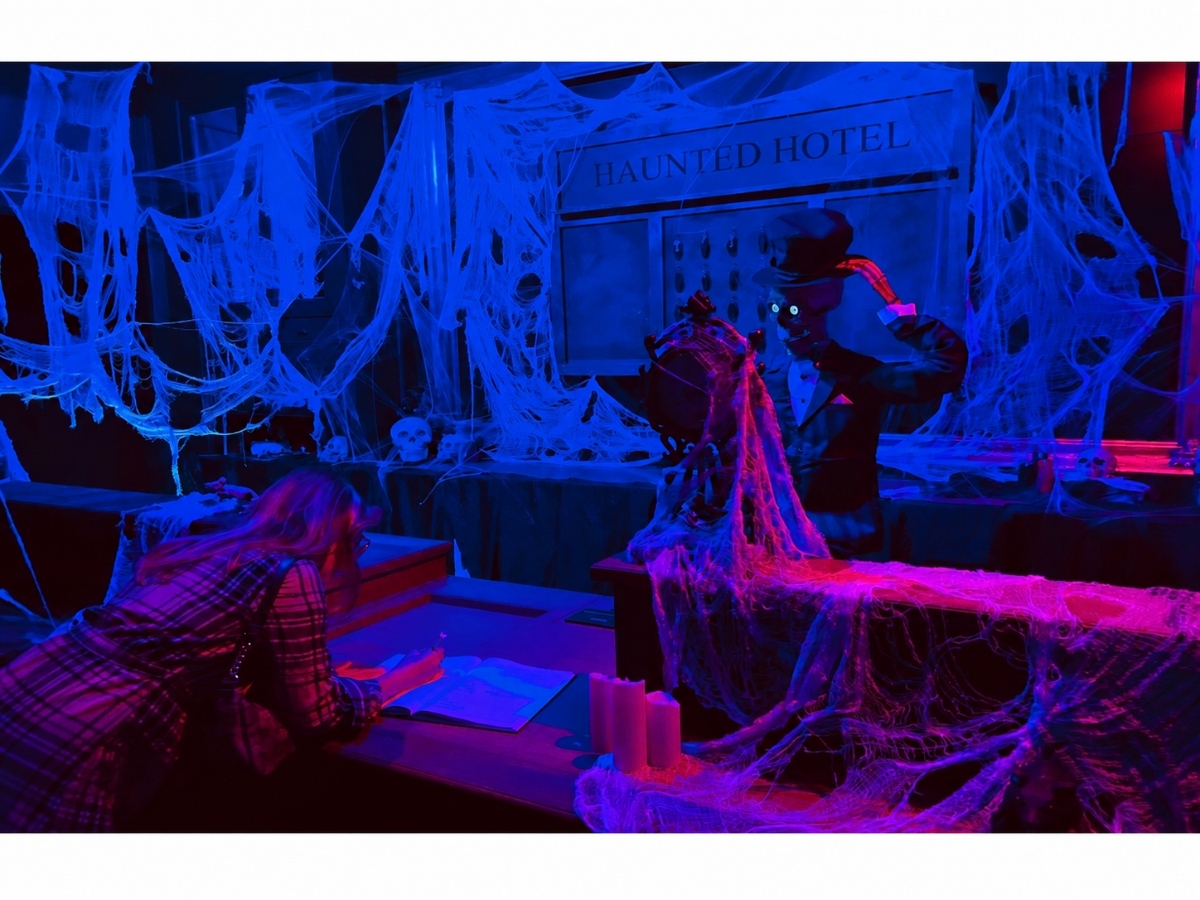 A guest signs in at the Haunted Hotel-themed area inside Halloween House Long Island in Greenlawn.