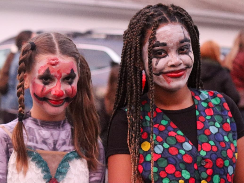 Two attendees show off their spooky clown makeup and colorful costumes during a Girl Scouts of Suffolk County Halloween celebration.