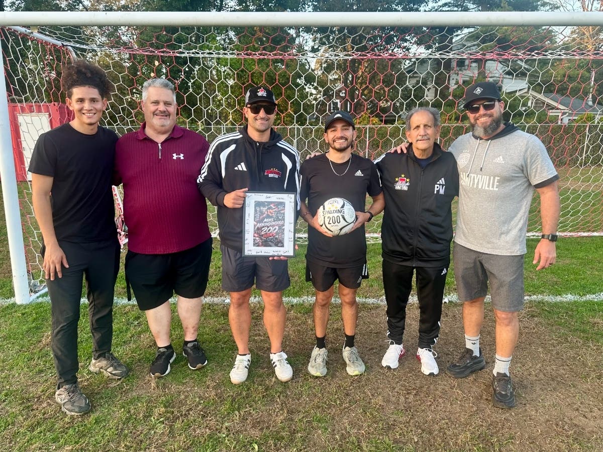 Amityville boys soccer head coach Mike Abbondondolo, center, celebrates his 200th career victory alongside members of his coaching staff. From left: Cristian Escobar, John Boell, Chris Gannon, Abbondondolo, Mike Abbondondolo Sr. and Greg McCoy.