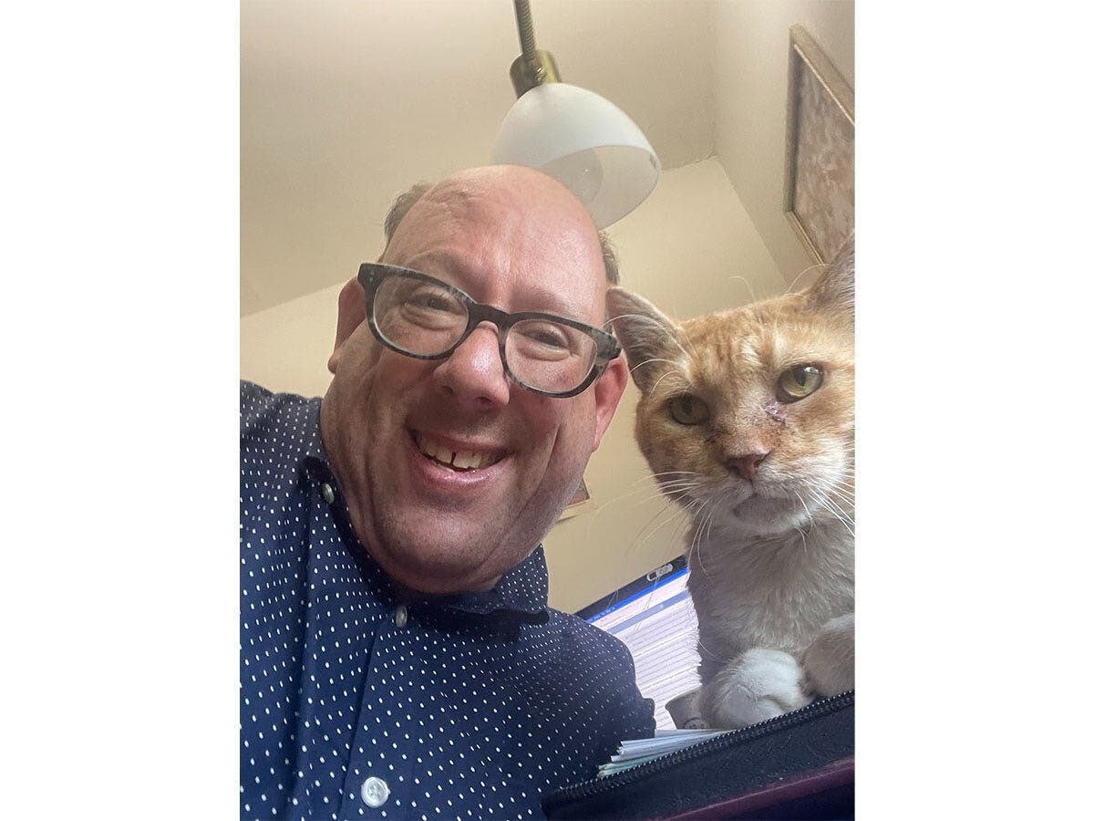 Cedarhurst resident Marc Berlin with his therapeutic healing cat, Sunny. Berlin, who has cerebral palsy, draws on his personal experiences navigating the health care system in his work as an independent patient advocate.