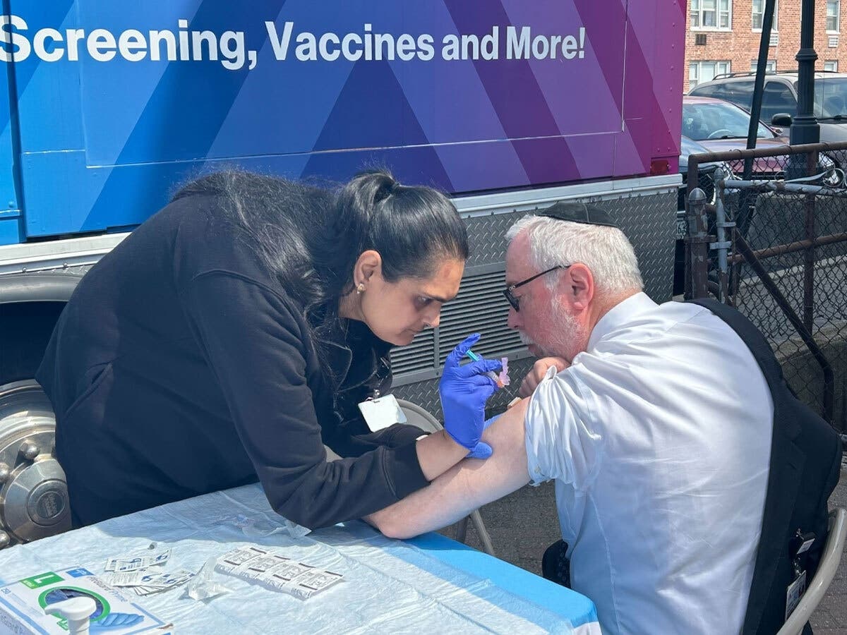 Dr. Aaron E. Glatt receives a pneumococcal vaccine outside the Freeport Memorial Library. 