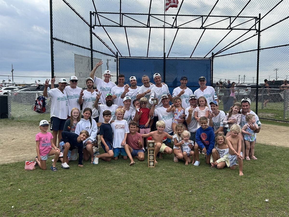 The Sun and Surf Beach Club softball team celebrates its title win with some of its smallest fans. 