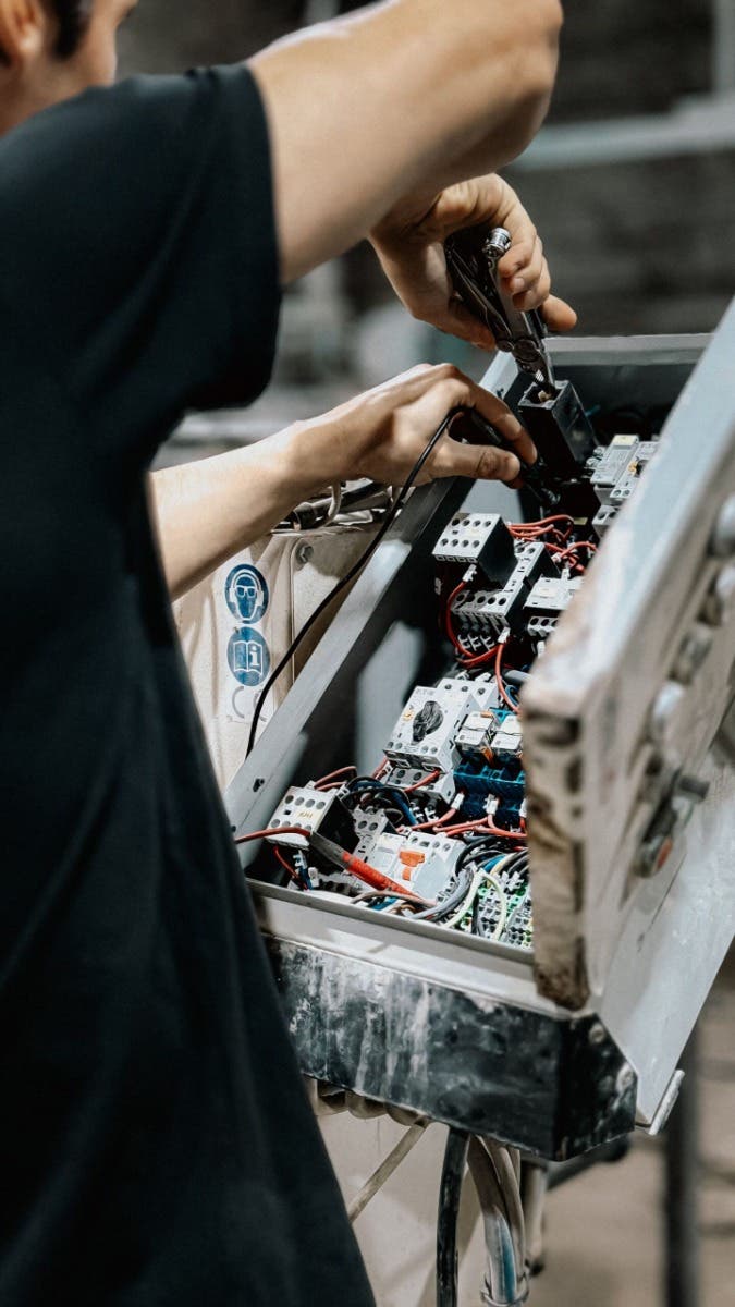 Commercial electrician working on an electrical control panel